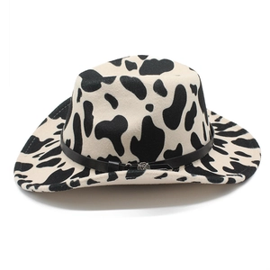 Detail of cow print fedora featuring a black leather band and silver floral metal buckle
