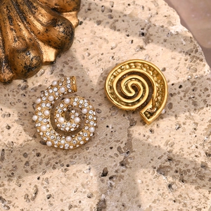 Macro shot of 18K gold plated conch earrings with white crystals and pearls