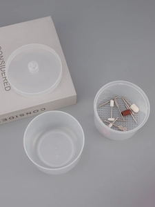 Macro view of translucent frosted nail drill storage box with assorted metal bits