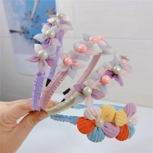 Detailed view of handmade mesh flower headbands with pearl accents in four pastel colors