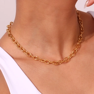 Detail of chunky gold-plated 18K stainless steel link chain necklace on model