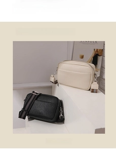 Detail of lychee pattern microfiber leather bags with striped detachable straps