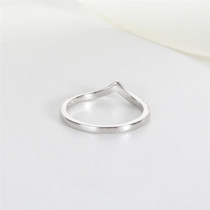 Macro shot of silver V-shaped stacking ring with sparkling stones and polished finish