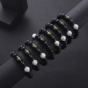 Close-up of black onyx and white turquoise bead bracelets on black jewelry display stand