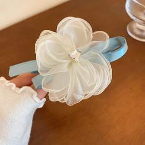 Detail of organza flower hair clip with heart rhinestone and light blue satin ribbon