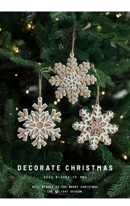 Close-up of rustic double-layered wooden snowflake ornaments hanging on a Christmas tree