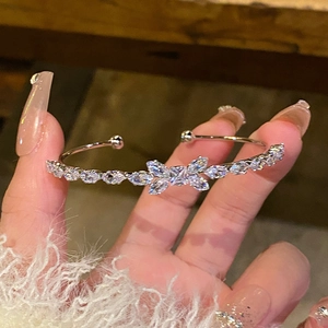 Detailed shot of open silver bracelet with butterfly zircons and marquise stones