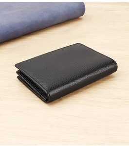Close-up of black litchi grain leather business card holder on a wooden background