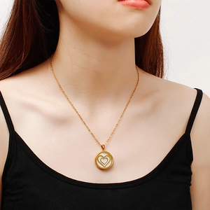 Golden stainless steel necklace featuring a layered heart pendant on female neck