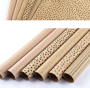 Detail of six brown kraft gift wrapping paper rolls with geometric and heart patterns
