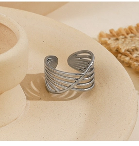 Macro shot of silver multi-layer crossover open ring on a ceramic plate background
