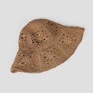 Close-up of bohemian foldable straw hat showing intricate hollow flower weave texture