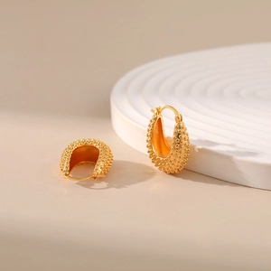 Chic 18K gold plated oval hoop earrings with textured beaded pattern on white display