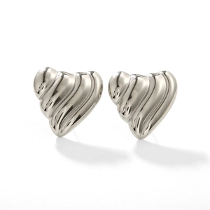 Détail de boucles d'oreilles cœur argenté avec texture ondulée et fini poli
