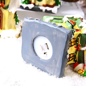 Vue du socle de maison de Noël en résine avec compartiment pile et interrupteur LED