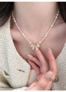 Elegante parelketting met sprankelende zirkoon strikhanger gedragen op een model