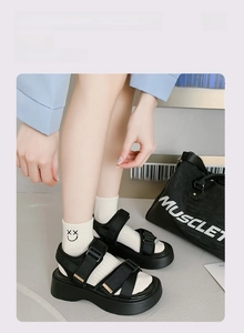 Detail of white cotton low socks featuring cartoon smiley embroidery and platform sandals