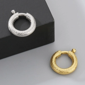 Detail of gold and silver textured round spring ring clasps with diamond pattern