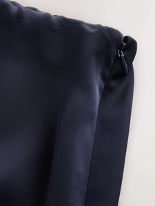 Detail shot of invisible zipper closure on dark satin lace patchwork skirt fabric