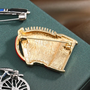 Detailed macro view of gold-plated horse brooch back with secure safety pin closure