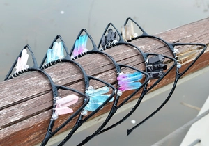 Detail view of crystal cat ear headbands with natural raw stone clusters on wood