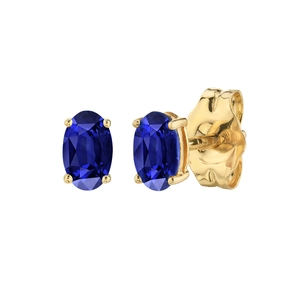 Detailed view of oval blue sapphire stud earrings with four-prong gold-tone setting