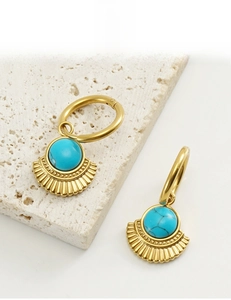 Close-up of fan-shaped 18K gold-plated earring with turquoise inlay and radial textures