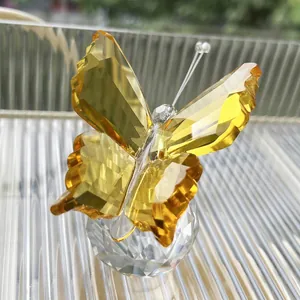 Elegant yellow faceted crystal butterfly ornament on clear spherical base for home decor