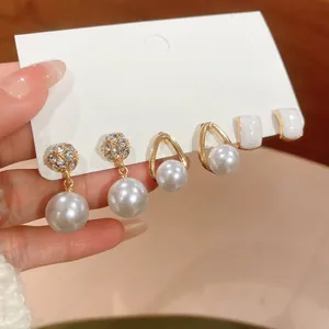 Detail of three-pair vintage pearl earring set with gold accents on display card