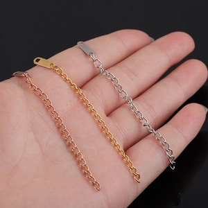 Three stainless steel necklace extender chains in rose gold, gold, and silver on a palm