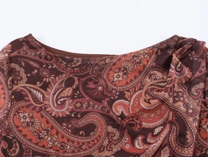 Gros plan du col rond sur une robe en maille avec motif imprimé cachemire marron