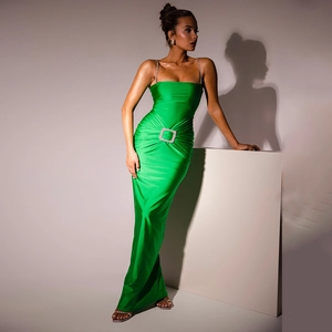 Detail of green satin maxi dress showing slim fit cut and sparkling rhinestone waist buckle
