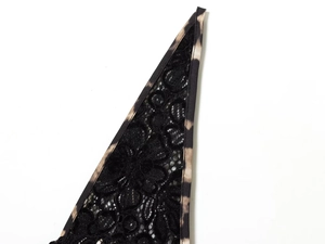 Detailed macro shot of elegant black lace texture and leopard print hem stitching