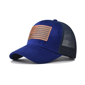 Vista dettagliata del cappellino trucker in pelle scamosciata blu con patch bandiera USA