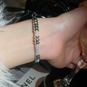 Detail of 18K gold plated zircon rivet buckle bracelet worn by model for luxury styling