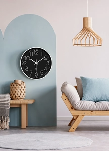 Detail of 12-inch radio controlled wall clock in minimalist black and white on blue wall