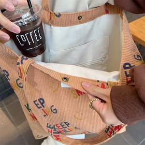 Interior view showing corduroy tote bag lining with zipper pocket and magnetic snap button