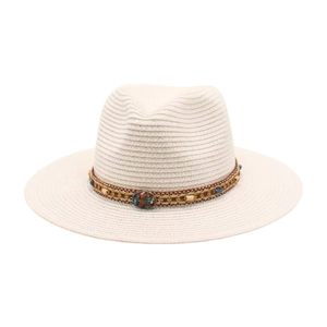 Détail d'un chapeau de paille beige clair avec ruban ethnique orné de pierres