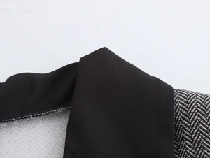 Detail shot of black contrast lapel on a grey herringbone wool blazer for women