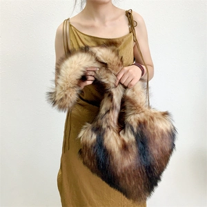 Detail of a large brown faux fur shell bag styled with a gold dress for a winter look