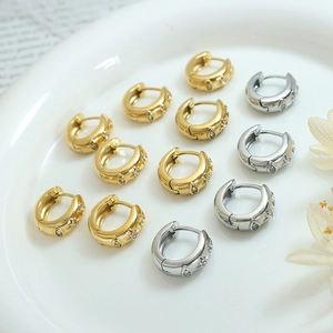 Boucles d'oreilles vintage dorées et argentées avec étoiles zircon sur plat blanc