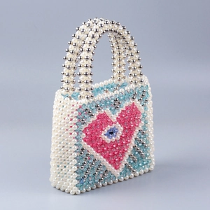 Detail of handcrafted beaded handbag featuring colorful crystal hearts and silver pearls
