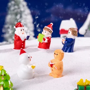 Miniature Christmas resin figurines including Santa and choir on decorative snow