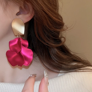 Detail shot of long rose red petal tassel earrings with a gold metallic finish stud