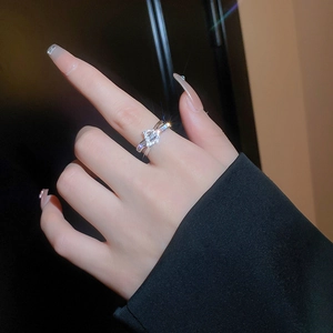 Close-up of a silver zircon double-layered ring with sparkling stones on a woman's finger