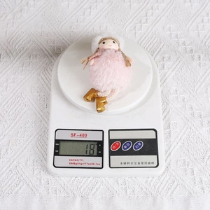 Pink plush angel Christmas ornament weighs 18g shown on a digital scale for measurement