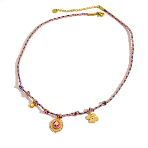 Dettaglio di bracciale colorato in corda intrecciata con ciondoli a stella e quadrifoglio