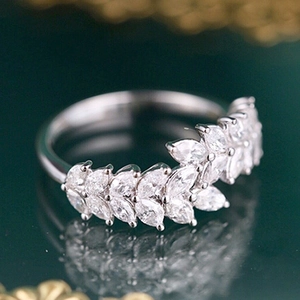 Macro shot showing marquise-cut gems and the intricate leaf-shaped design of the ring