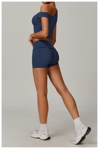 Détail d'un ensemble de yoga bleu marine avec haut asymétrique et short de sport taille haute