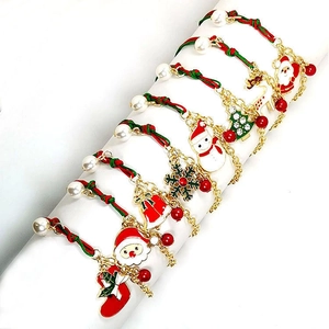 Christmas charm bracelets with Santa, tree, and snowflake pendants on woven red and green ropes